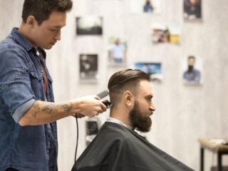 10 модных мужских стрижек 2022, которые подойдут всем, и 10 причесок для мужчин с залысинами Мужчину с бородой стрижет парикмахер